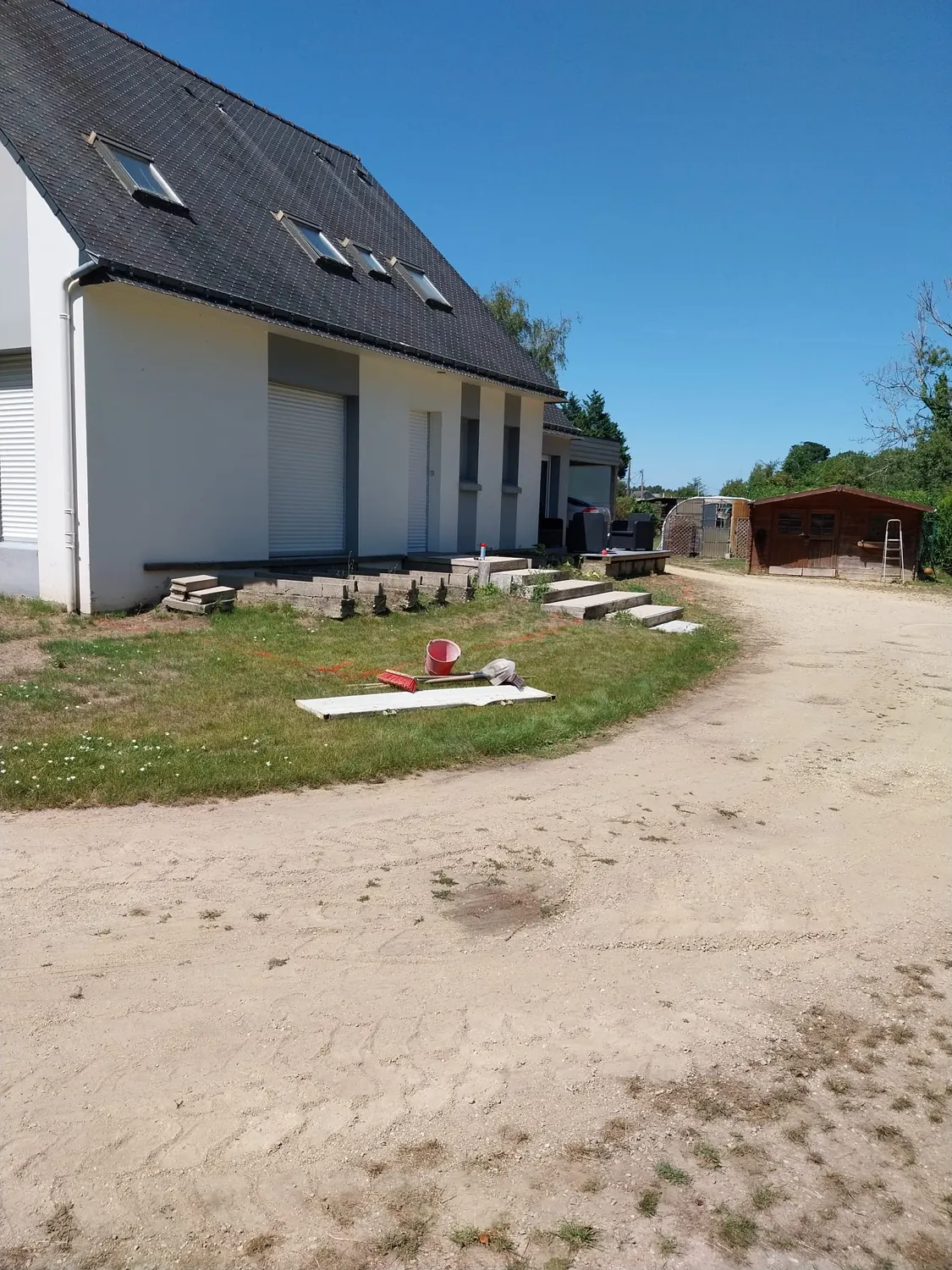 Chemin en sable stabilisé en courbe autour d'une maison avant enrobé (avant)