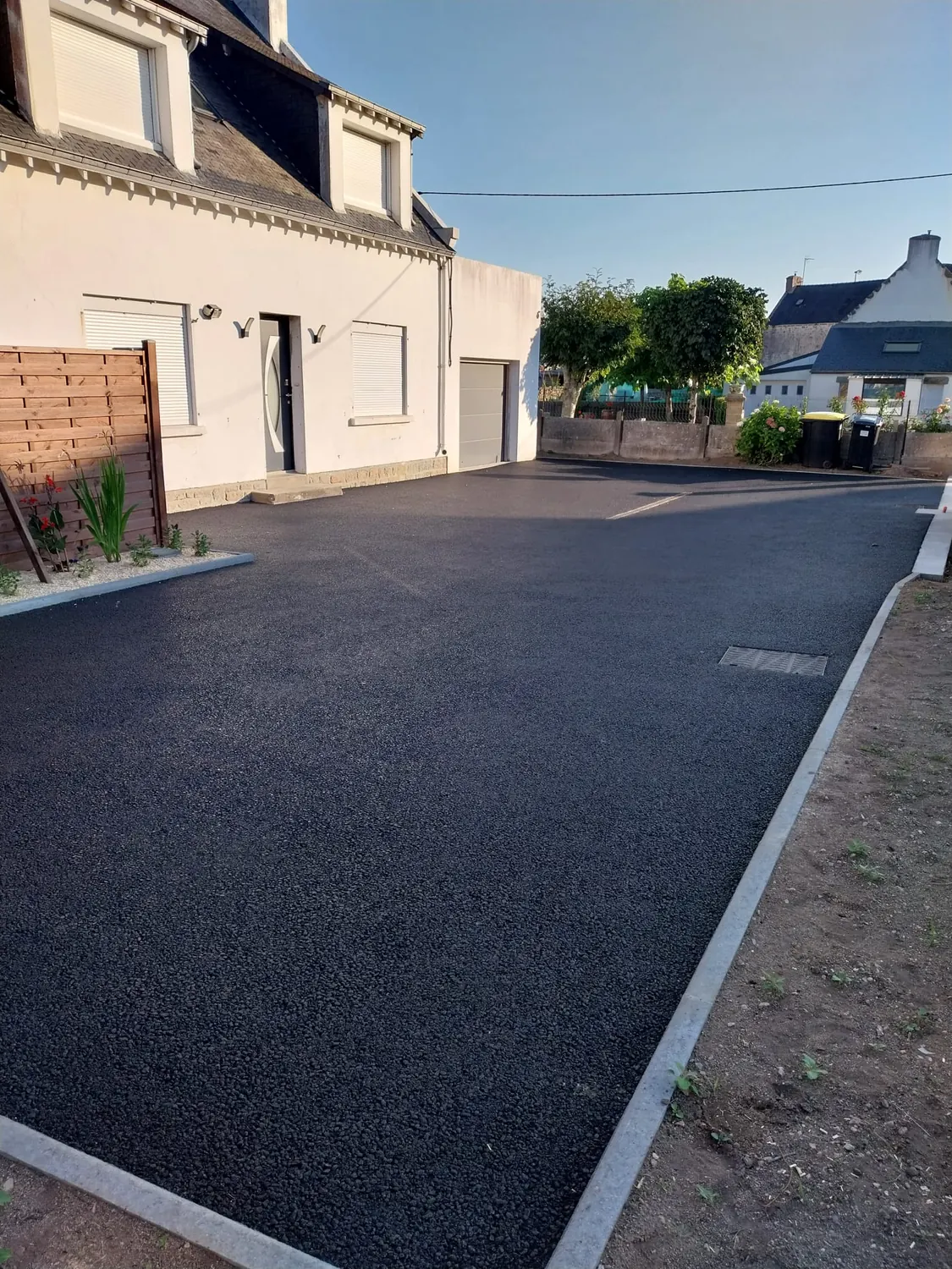 Allée en enrobé avec bordure béton et massif de plantes