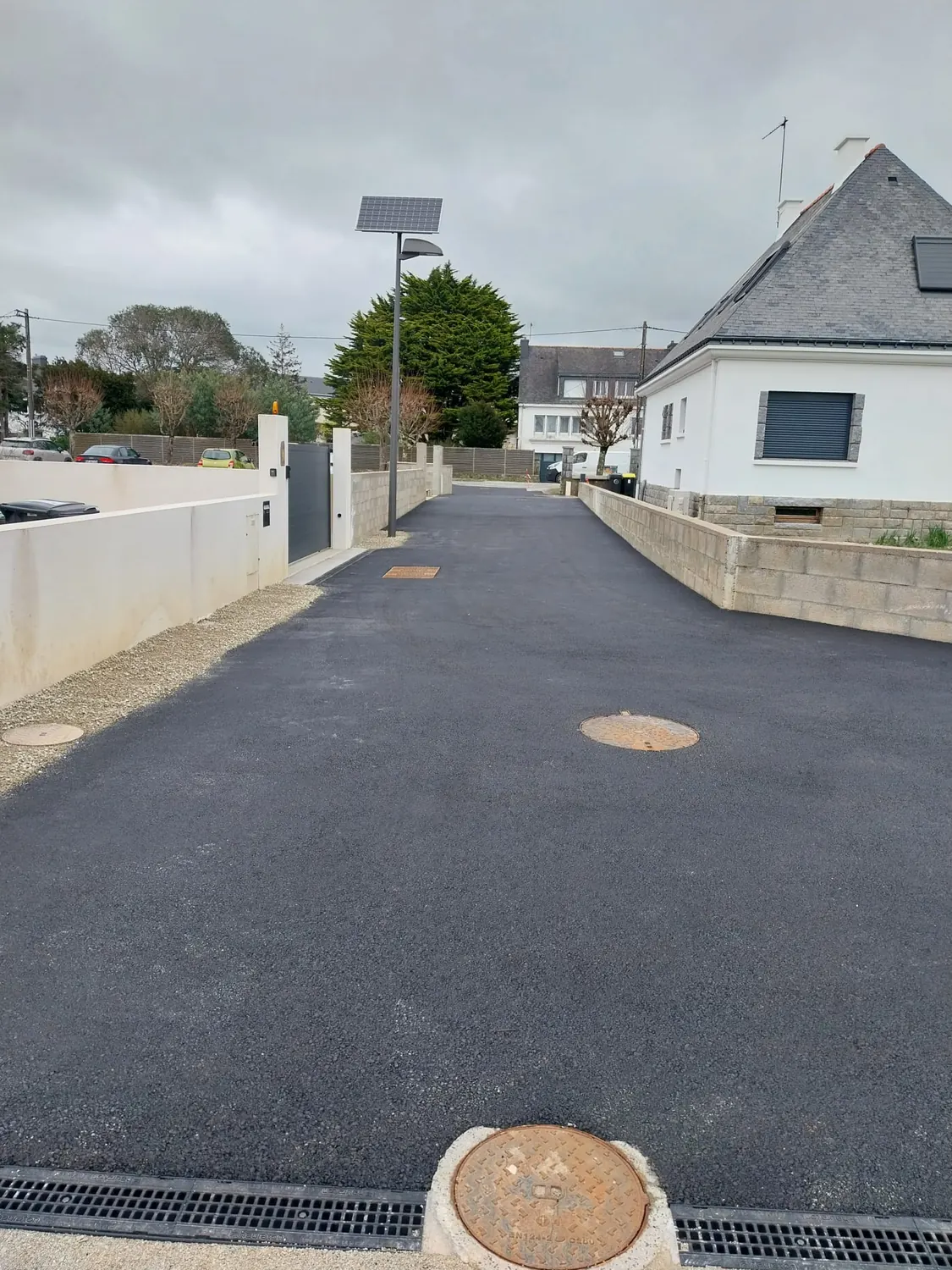 Enrobé neuf avec caniveau à grille et lampadaire solaire