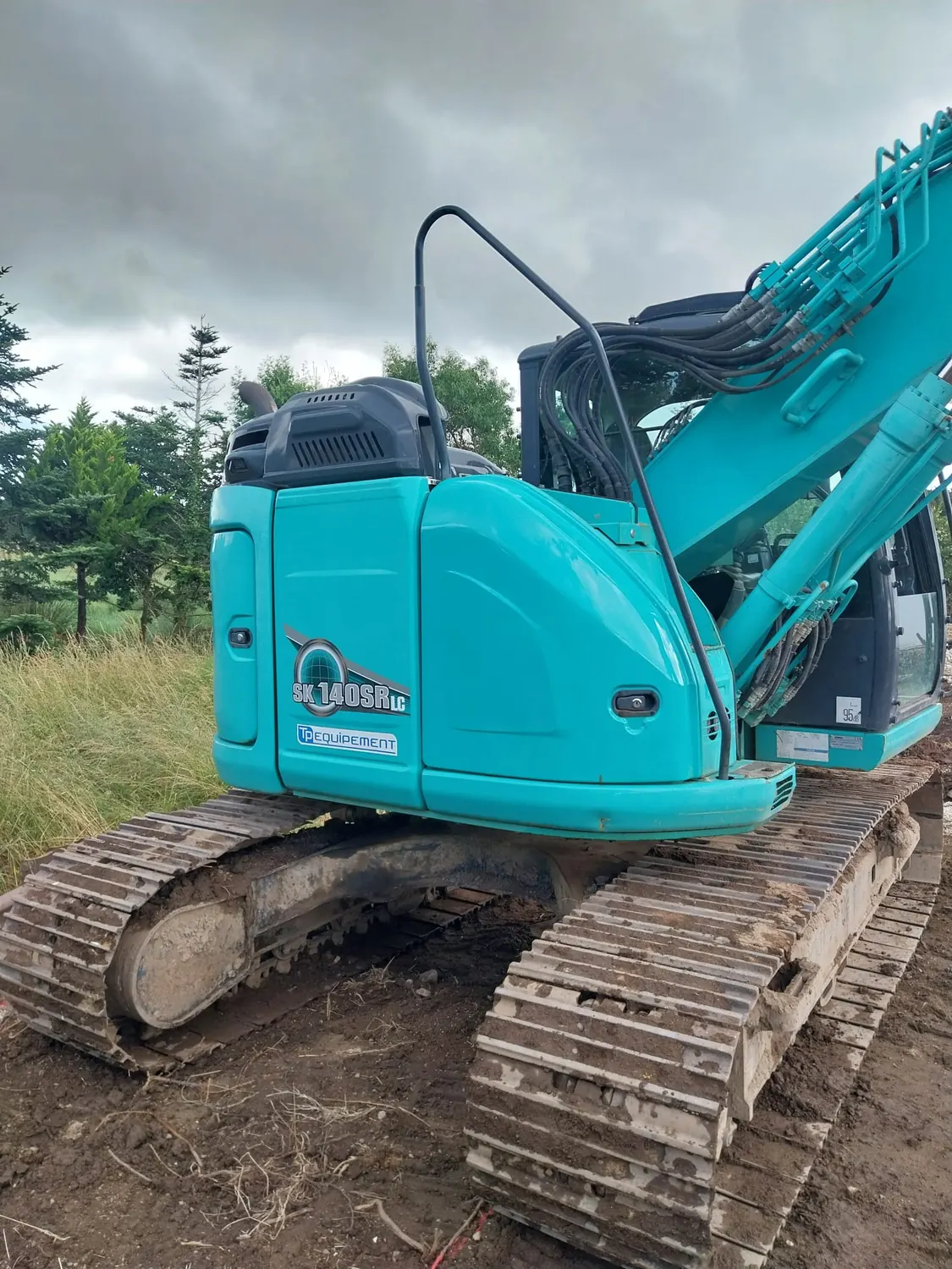Pelle sur chenilles turquoise vue de l'arrière sur un chantier