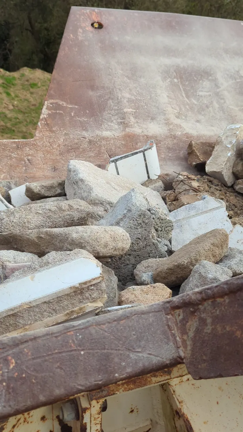 Gravats de béton et de pierre dans la trémie du concasseur