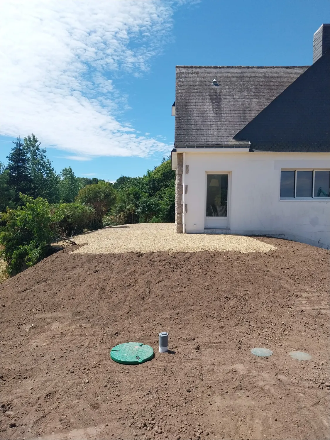 Couvercle vert de regard d'assainissement sur terrain fraîchement terrassé