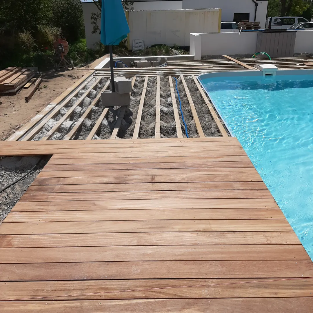 Terrasse en bois massif au bord d'une piscine