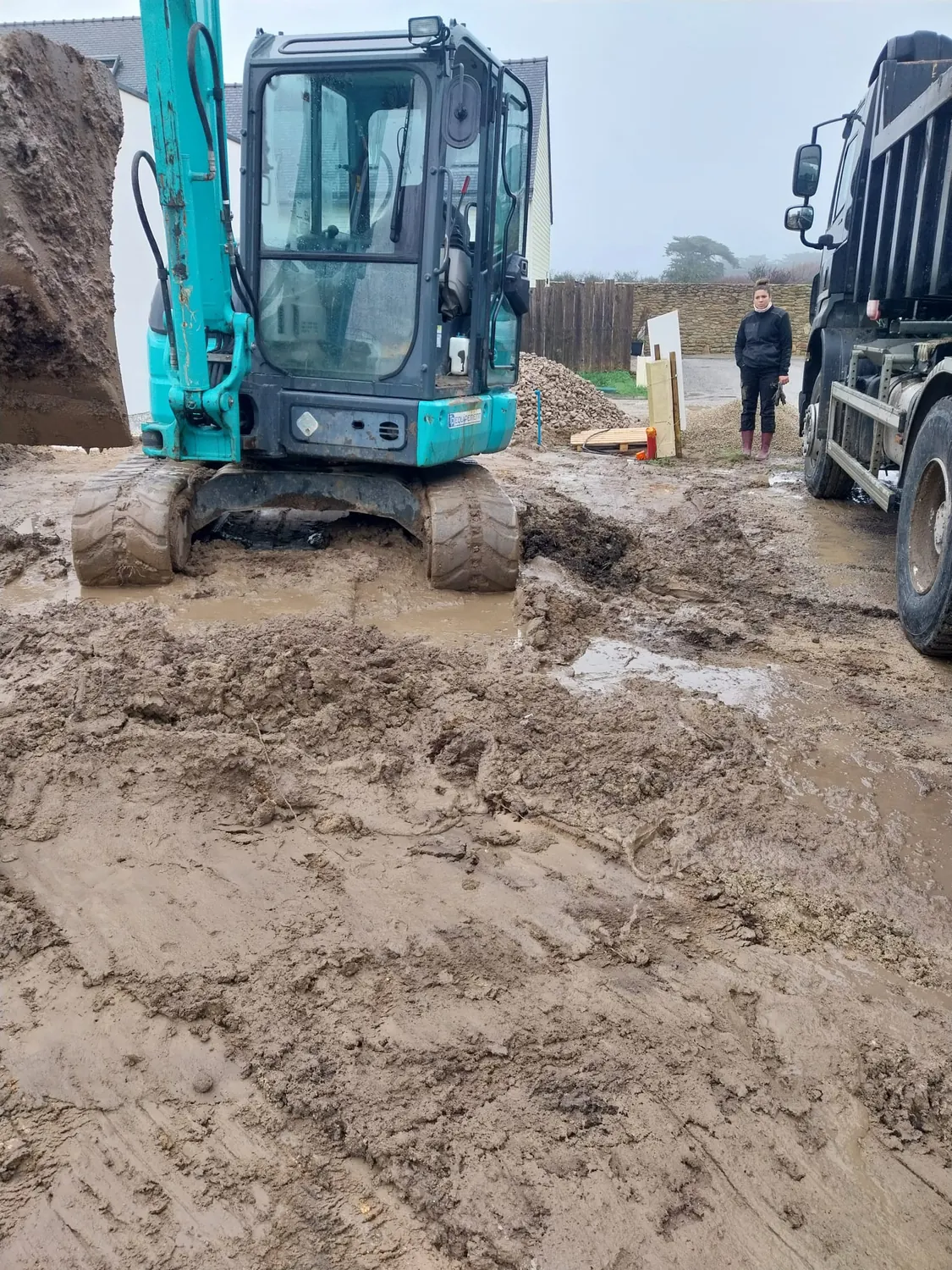 Mini-pelle et camion benne sur un chantier de terrassement
