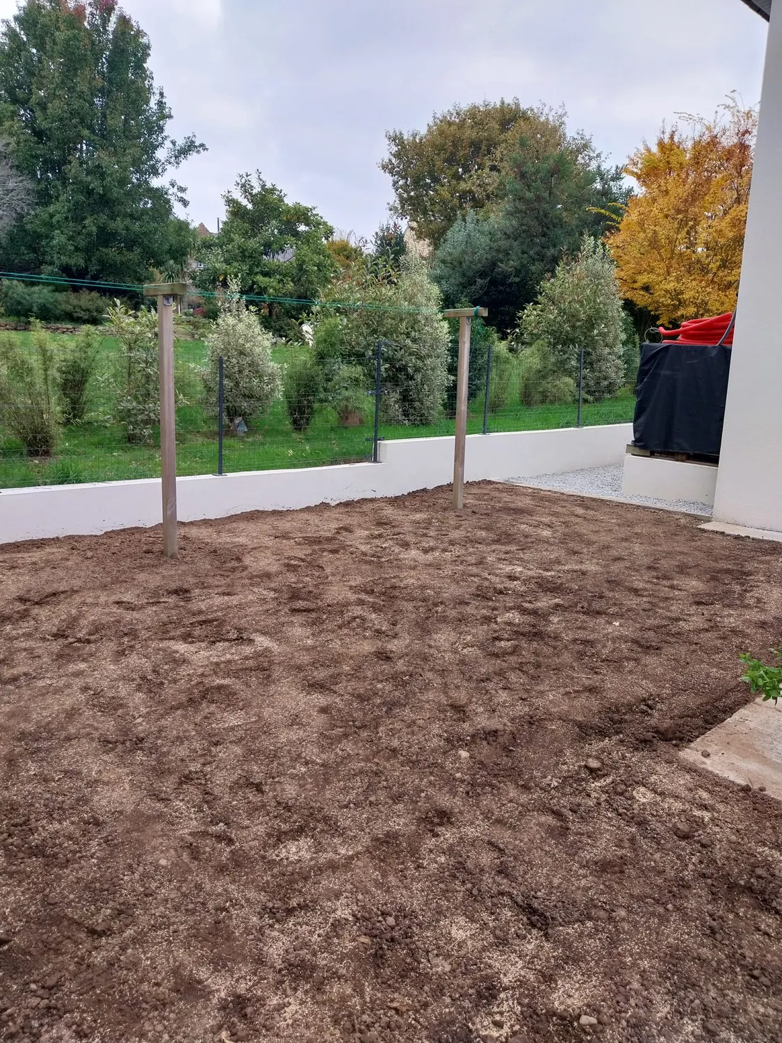 Terre préparée et nivelée pour un jardin devant une maison